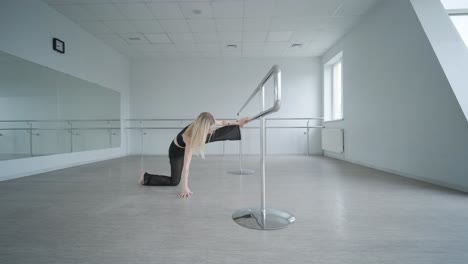 chica en forma con ropa negra actuando contemporáneamente. bailarina muestra movimientos fluidos, cuerpo y manos ondas en la habitación blanca. coreografía de danza de ballet moderno. joven se mueve suavemente