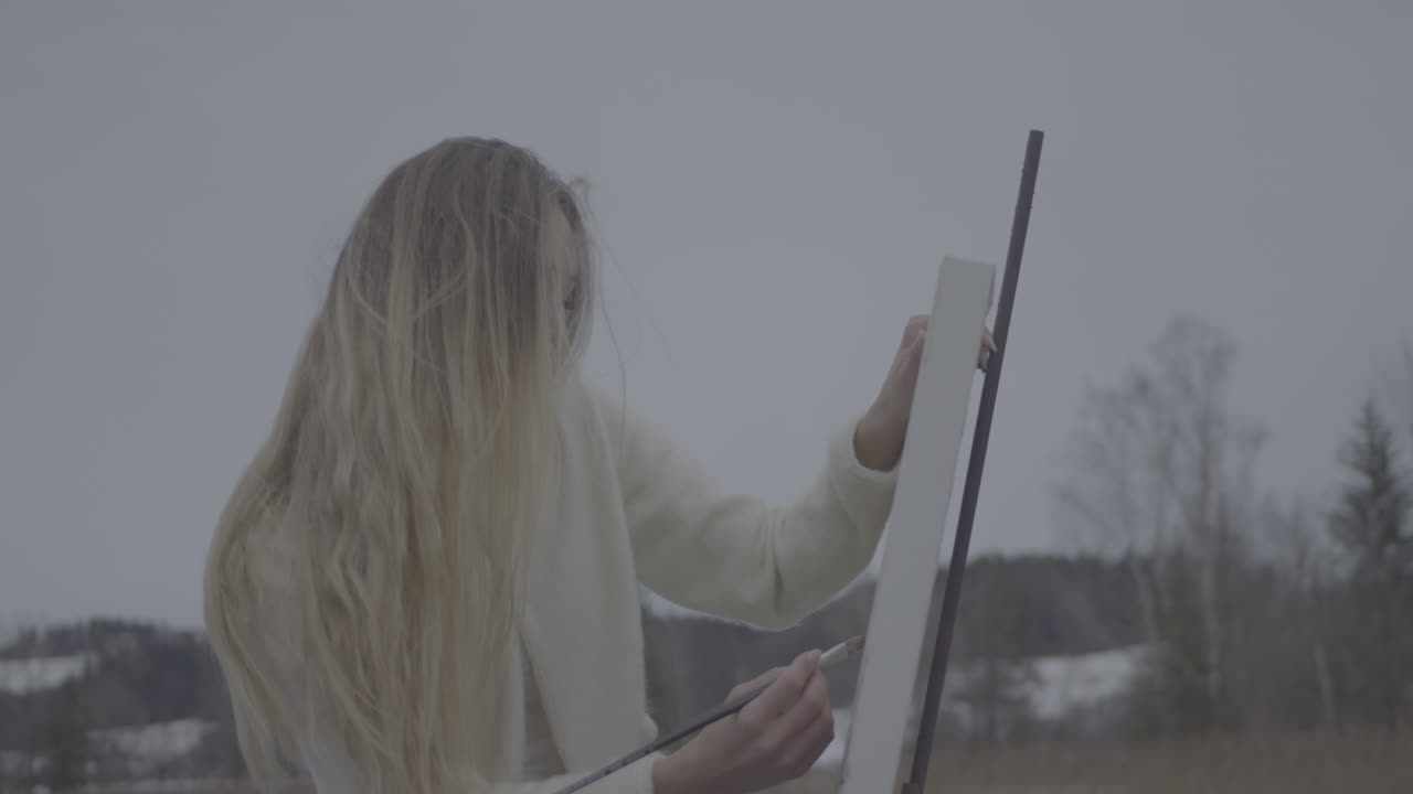 Woman Painting Outdoors in Winter Landscape