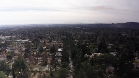 low aerial shot flying over christmas tree lane within the eaton fire burn zone in altadena, california. 4k