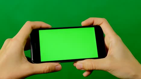 mujer de negocios usando un teléfono móvil de pantalla verde en blanco sobre un fondo verde.