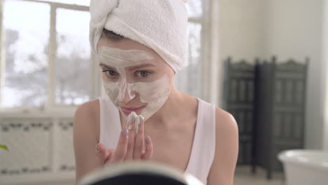 mujer aplicando mascarilla facial para el cuidado de la piel