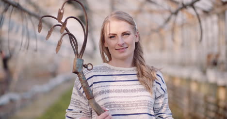 successful female gardener holding hoe