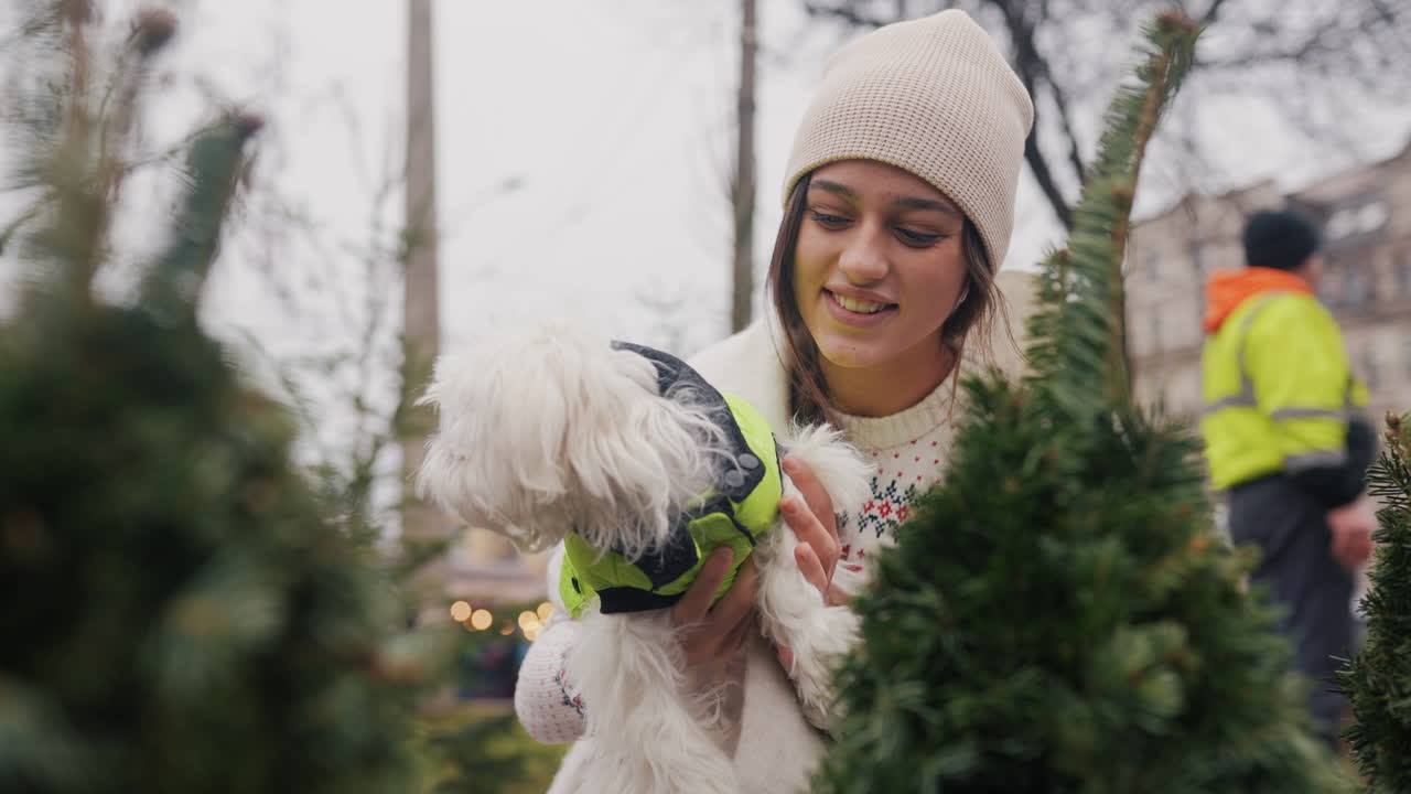어린 여자 가 개 와 함께 크리스마스 트리 를 구입 하고 있다