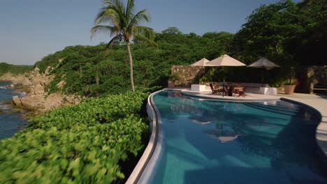 Aerial-view-of-resort-pool-revealing-to-nearby-dense-forest