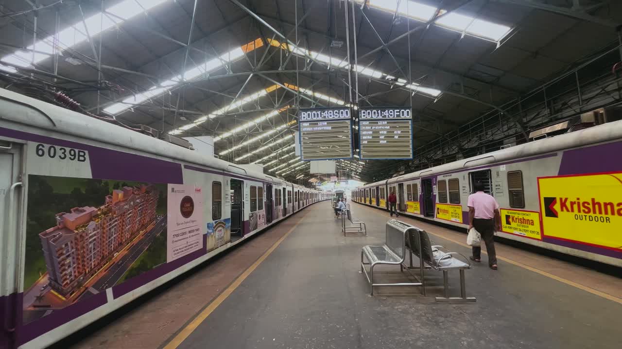Passengers and commuters running for local train on Churchgate station with digital display boards