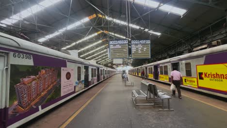 passengers and commuters running for local train on churchgate station with digital display boards