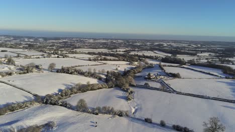 Frío-Invierno-Nevado-Británico-Patchwork-Tierras-De-Cultivo-Campo-Escena-Rural-Pan-Aéreo-Izquierda-Hacia-Adelante-Al-Amanecer