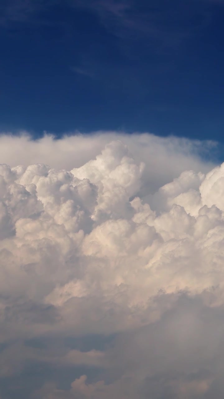 Dramatic white cloudscape above the sky in vertical aerial view.