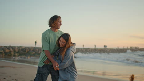 couple playing on the beach at sunset