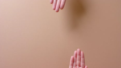Hands-of-caucasian-people-holding-blood-drop-on-beige-background-with-copy-space,-slow-motion