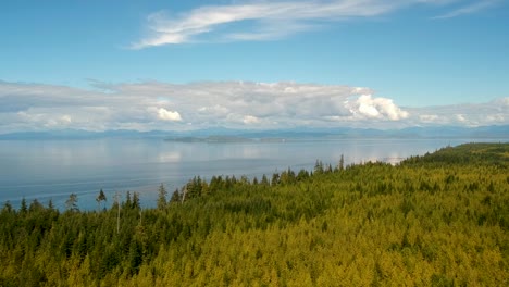 drone shot with island forest mountains clouds and ocean