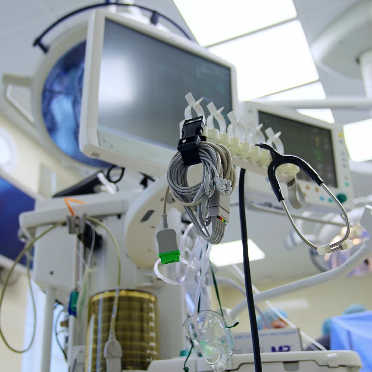 Machine for lung ventilation working in the surgical theatre. Low angle view. Doctors working at operation at backdrop in blur