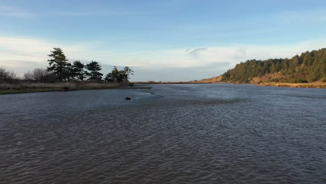 Aerial-flying-low-and-rising-over-Sixes-River,-Cape-Blanco-State-Park