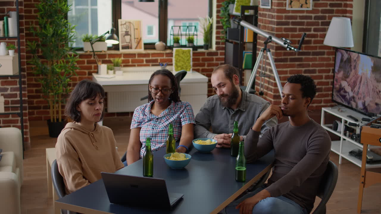 Grupo diversificado de amigos assistindo a vídeos da internet no laptop