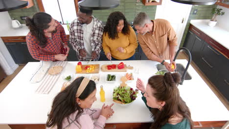 Felices-Y-Diversos-Amigos,-Hombres-Y-Mujeres,-Preparando-Comida-Juntos-En-La-Cocina.