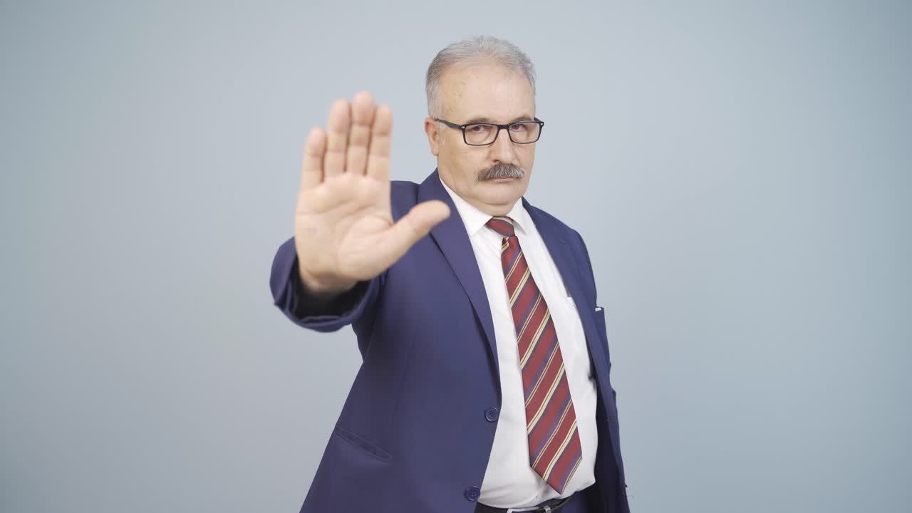 un hombre de negocios dice "deténgase" a la cámara.