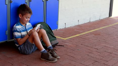 Schoolboy-using-mobile-phone-in-locker-room-4k