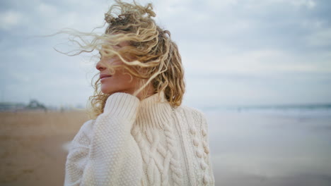 Mujer-Serena-Mirando-La-Cámara-Disfrutando-De-La-Playa-De-Otoño.-Hermosa-Mujer-Sonriente