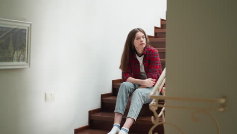 sad young woman sits on mansion staircase. female student worried of fail in important test sits on steps. lady has problems with college education