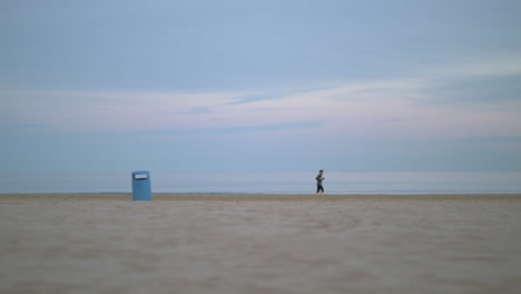 jogger running beside the sea on a cold day