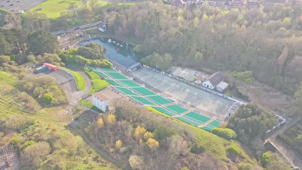 Le Théâtre en plein air de Scarborough, situé à Scarborough, Yorkshire du Nord, Angleterre, Royaume-Uni, avec son amphithéâtre en gradins, sa scène et la vallée boisée environnante près de la côte, vu en descente de drone.