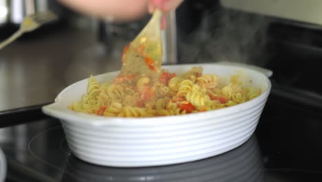 Mujer-Revolviendo-Pasta-Con-Salsa-Para-Pasta-Y-Tomates-En-Un-Tazón-Blanco