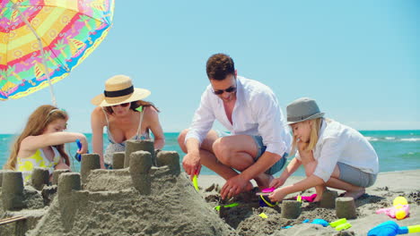 family building sandcastles on the beach