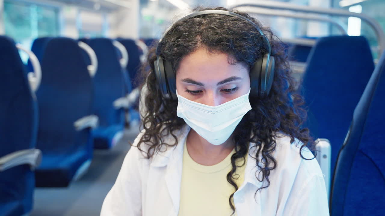 mujer con una máscara y auriculares en un tren