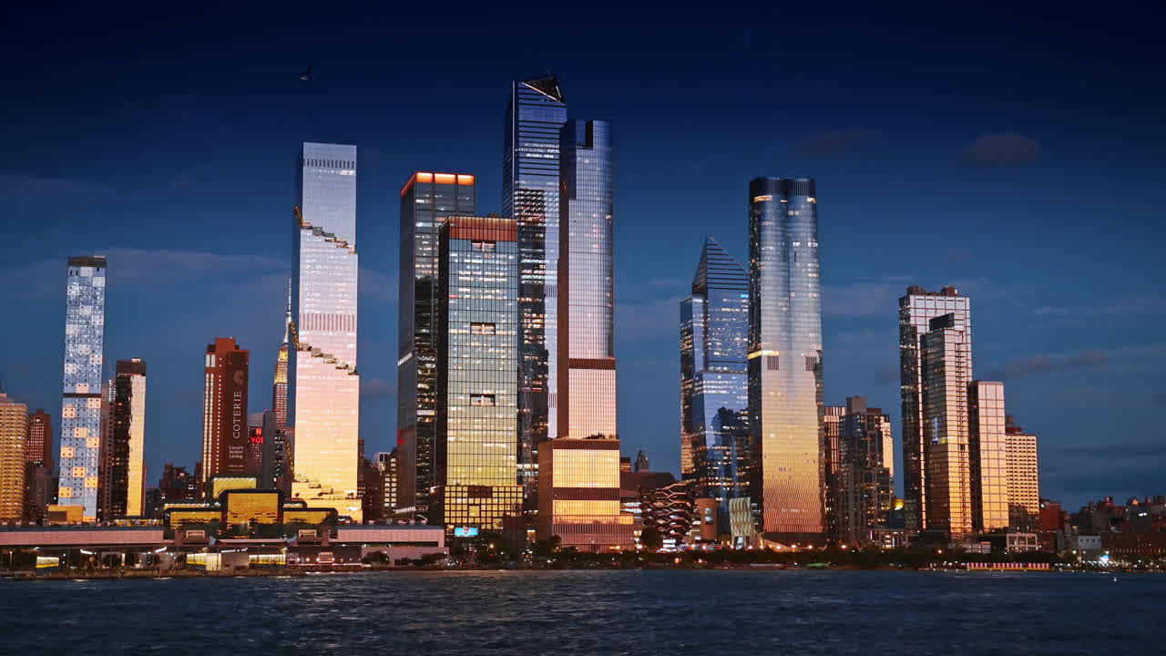 Nova York, EUA, 8 de novembro de 2025: horizonte de Hudson Yards brilhando ao entardecer. As torres de Hudson Yards brilham em luz quente durante o horizonte da hora azul