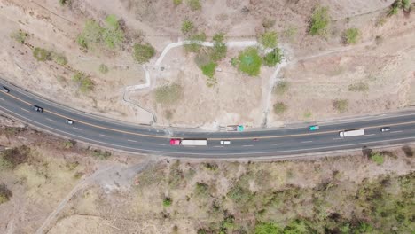 aerial drone view: a curved highway cutting through arid terrain