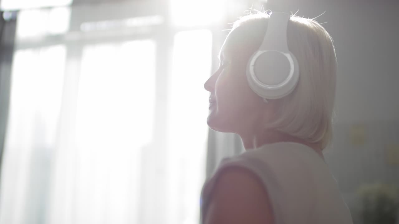 Woman in Headphones Enjoying Relaxing Music with Eyes Closed