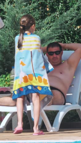 people sitting by the poolside of a resort swimming pool