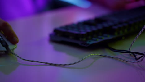 mano del ciberjugador usando el ratón en un primer plano de la habitación de neón. jugador de esport descansando en línea