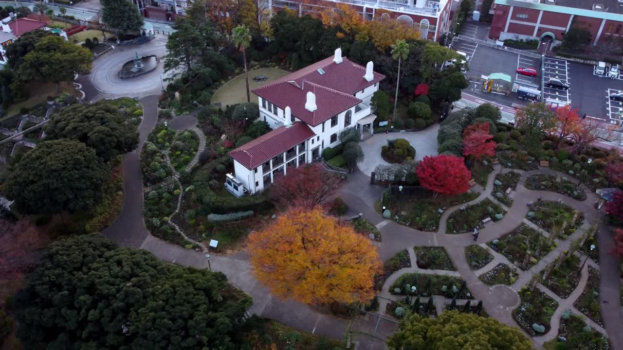 un edificio histórico rodeado de laberintos de jardín de otoño, al anochecer, vista aérea