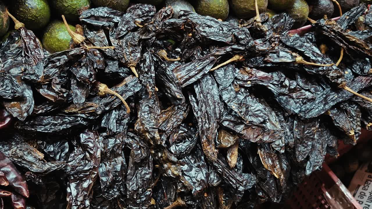 Large bags filled with dried chili peppers and spices on display at a traditional Mexican market