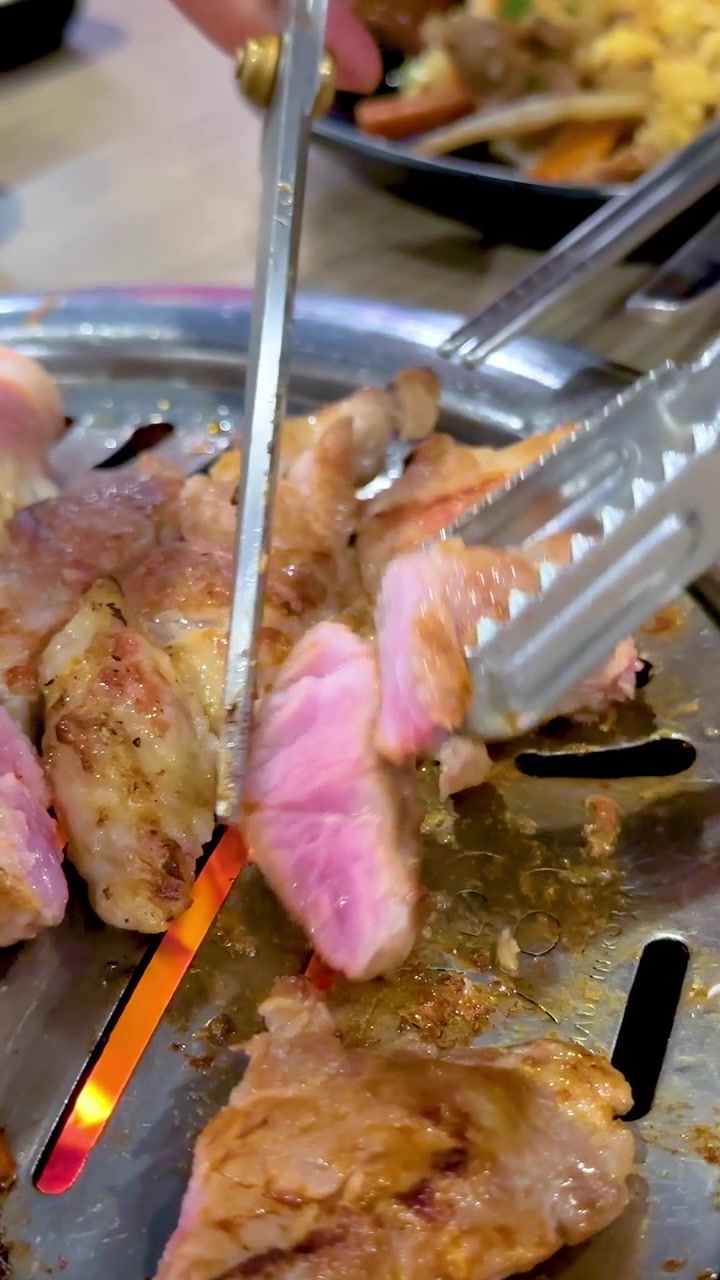 Close-up daging yang dipanggang di BBQ di Bangkok, menampilkan warna-warna cerah dan aksi memasak yang dinamis
