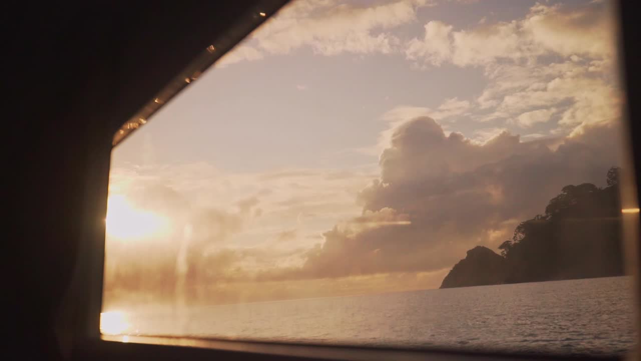 Sunrise over the ocean seen from the window inside a boat window