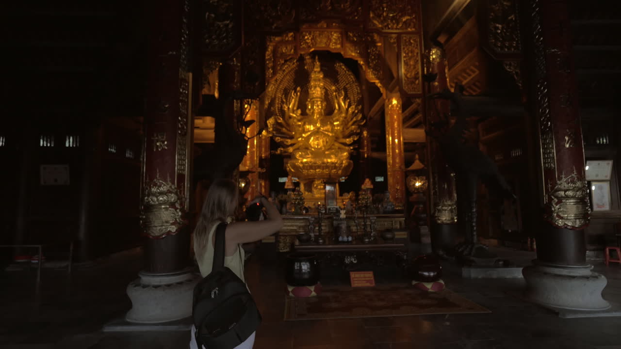 ベトナムのバイディン仏教寺院で像の写真を撮っている女性