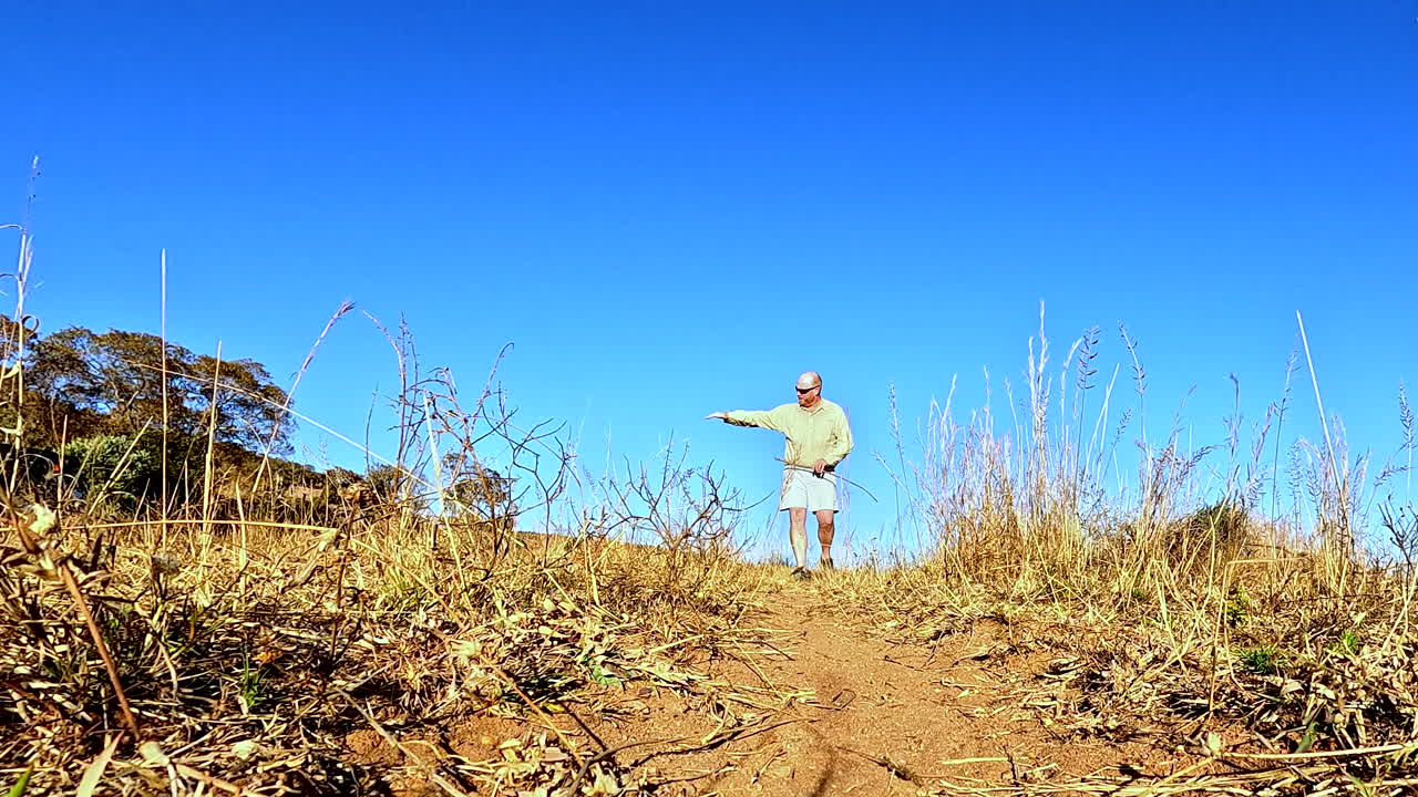 Safari guide on foot explain and demonstrates how to track animal spoor, low POV