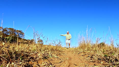 safari guide on foot explain and demonstrates how to track animal spoor, low pov