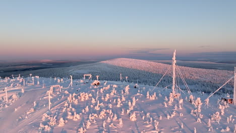 aerial tracking shot of the summit of the snowy salla fell, sunrise in finland