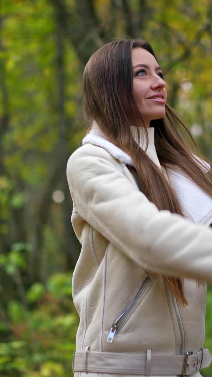 Pretty young woman in the park. Beautiful lifestyle portrait lady. Vertical video