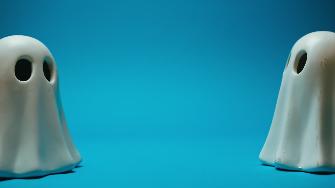 Little ghosts move on a blue background with copy space