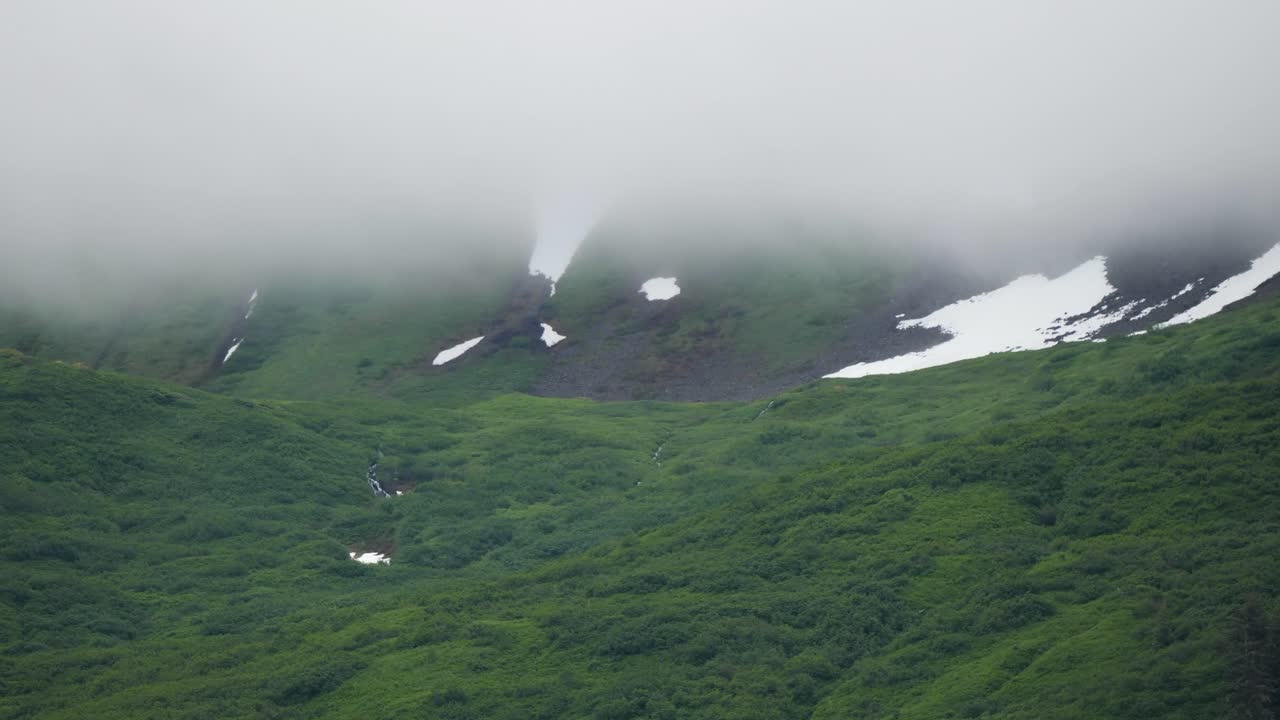Snow capped mountains covered by clouds, seen from Gastineau Channel, Juneau, Alaska