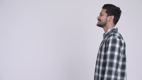 profile view of happy young bearded indian hipster man