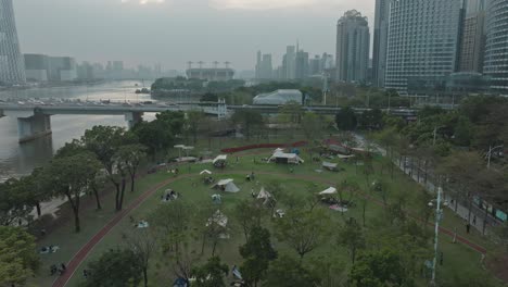 people camping outside in linjiang linear park by zhujian river in guangzhou, china