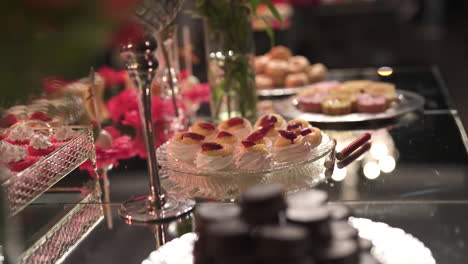 una mesa de postres con una variedad de dulces, decoración elegante y un cálido ambiente de fiesta