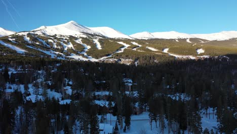 Aerial-viewing-forward-shot,-Scenic-view-of-top-of-a-mountain-in-Colorado,-Pine-trees-and-mountain-ranges-in-the-background