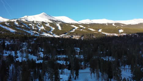 aerial viewing forward shot, scenic view of top of a mountain in colorado, pine trees and mountain ranges in the background