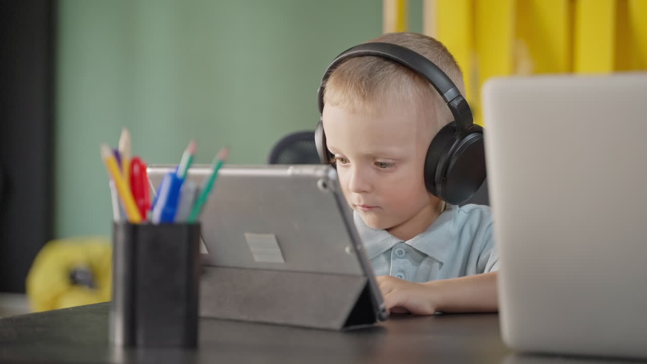 Child Studying on Tablet and Laptop